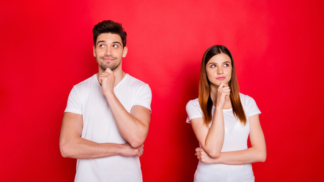 Young couple thinking against red background